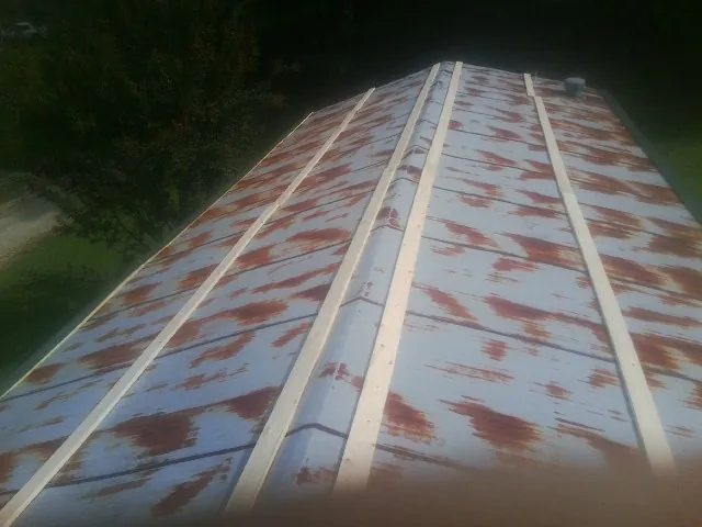 Rusted metal roof panels with new wood purlins before replacement — Storm Damage Roof Repair in Saunderstown by Roofing Brothers