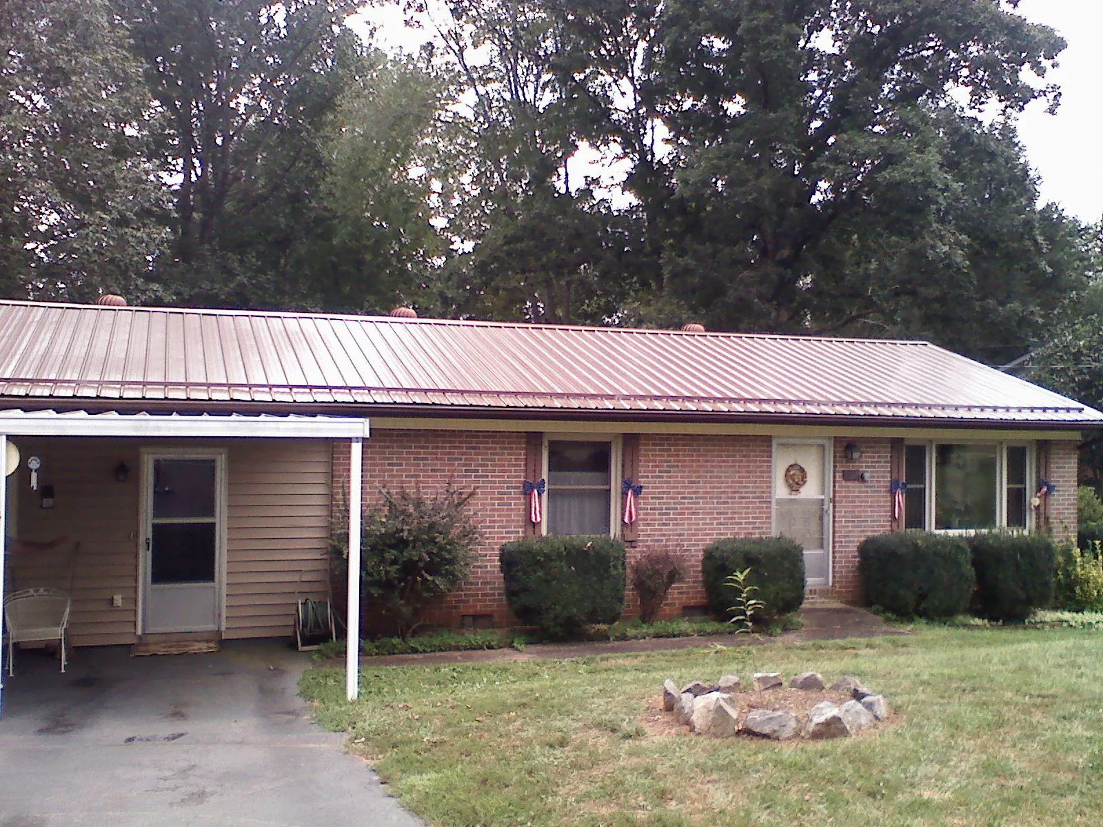 Bronze metal roof and carport on a brick ranch home — Roof Repair work by our crew in Saunderstown