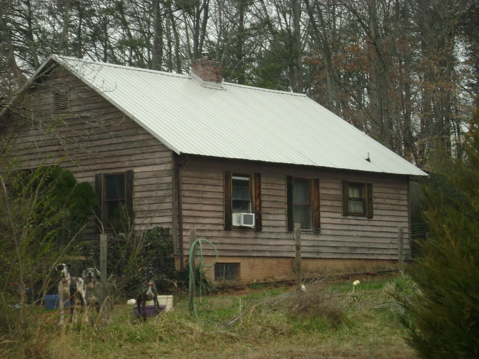 White metal roof on an old wood sided farmhouse, from a Metal Roof Installation job in Saunderstown